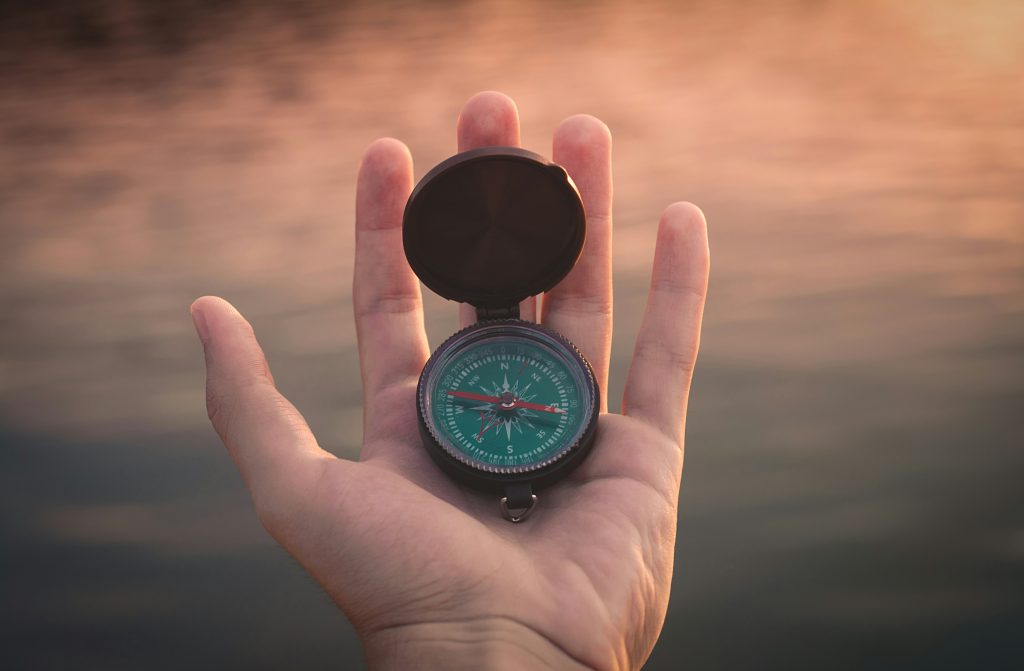 A brass compass resting on an old chart, for an article about losing the route back to the evidence.
